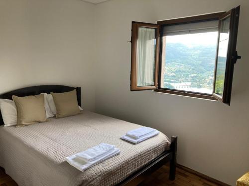 um quarto com uma cama com duas toalhas em Casa da Laija - Vistas rio e serra do Gerês no Gerês