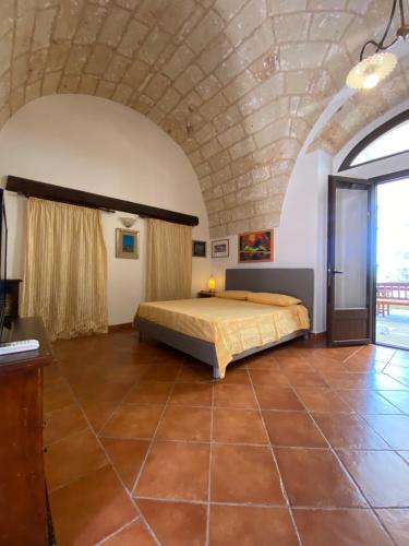 a bedroom with a bed in the middle of a room at Villa Emanuel in Alessano