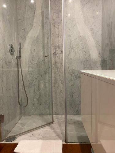 a bathroom with a shower with a glass door at Beach Front with Rooftop in Vila do Conde