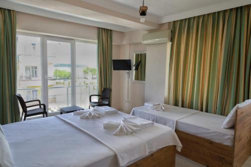 a hotel room with two beds and a balcony at Eceabat Doğa Pansiyon-Hotel in Eceabat