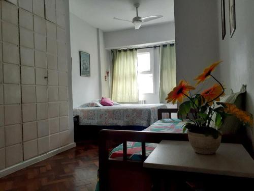 una habitación con 2 camas y una mesa con una planta en Apartamento Av Atlantica, en Río de Janeiro