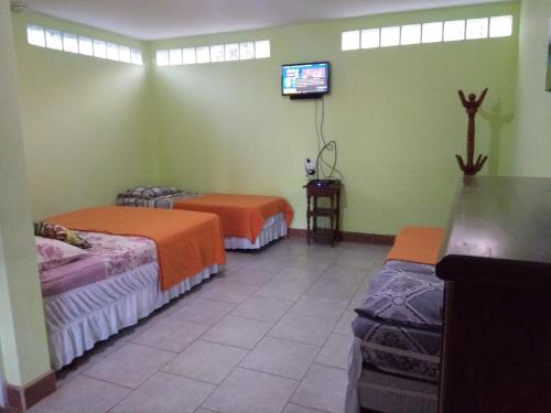 a room with two beds and a tv in it at El departamento de Romy in Puerto Iguazú