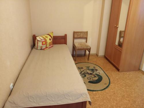 a small bedroom with a bed and a chair at Комфортные апартаменты на приватной територии in Izmail