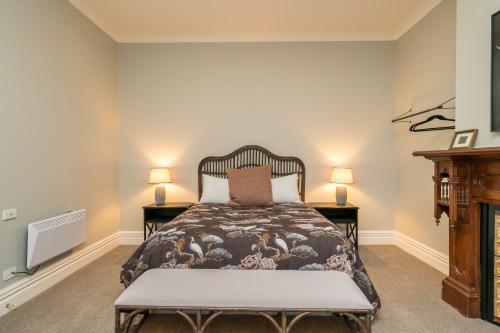 a bedroom with a bed with two night stands at Inner City Executive Living on Stuart Street in Dunedin