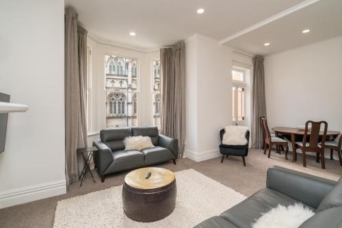 a living room with a couch and a table at Inner City Executive Living on Stuart Street in Dunedin