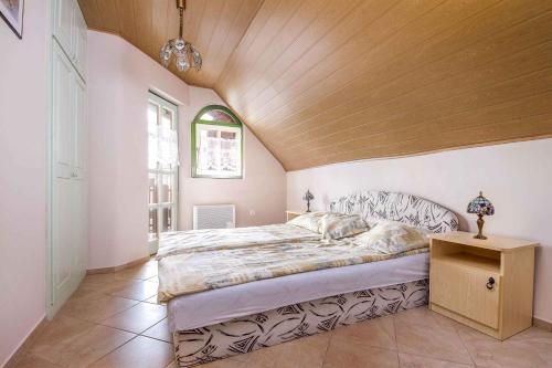 a bedroom with a large bed with a wooden ceiling at Apartments in Balatonmariafürdo - Balaton 19491 in Balatonmáriafürdő