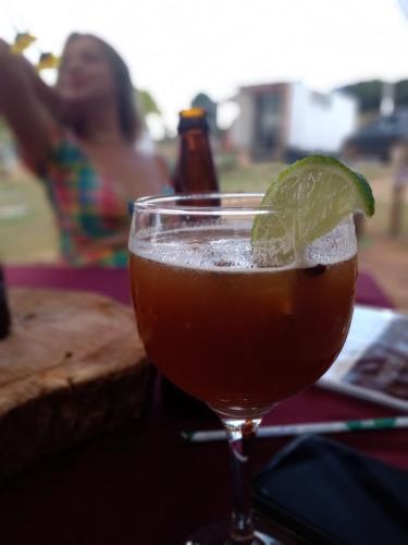 a drink with a lime in a glass on a table at Ecaffe Hotel Pousada Container - Coqueiral MG in Coqueiral