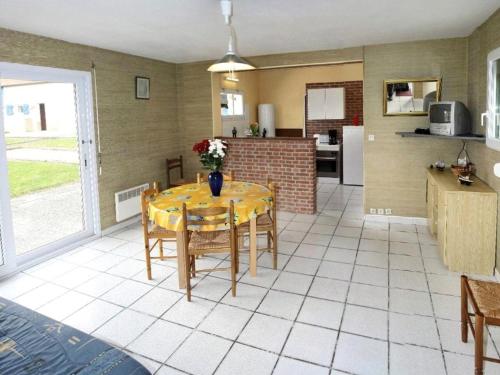 une salle à manger avec une table et une cuisine dans l'établissement Gites aux oiseaux, à Quesnoy-le-Montant