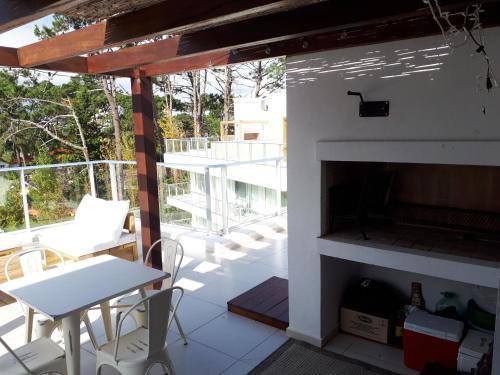 een woonkamer met een open haard en een tafel en stoelen bij Estudio con parrillero y vista al mar in Punta del Este