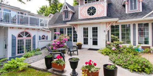 a house with a patio with flowers and plants at Gingerbread House Inn - We Are Open - Winter, Spring, Summer and Fall in Wolfville