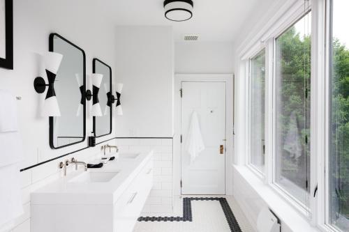 a white bathroom with two sinks and a window at The Amelia in Hudson