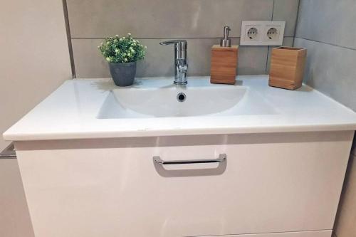 ein weißes Waschbecken mit Topfpflanze darauf in der Unterkunft Verano ETERNO en Mallorca - Alcudia! in Alcúdia