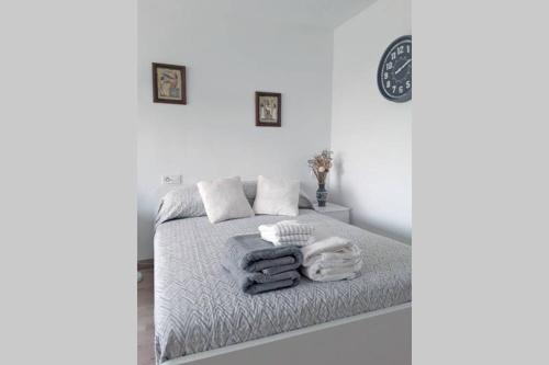 ein weißes Schlafzimmer mit einem Bett mit Handtüchern darauf in der Unterkunft Verano ETERNO en Mallorca - Alcudia! in Alcúdia