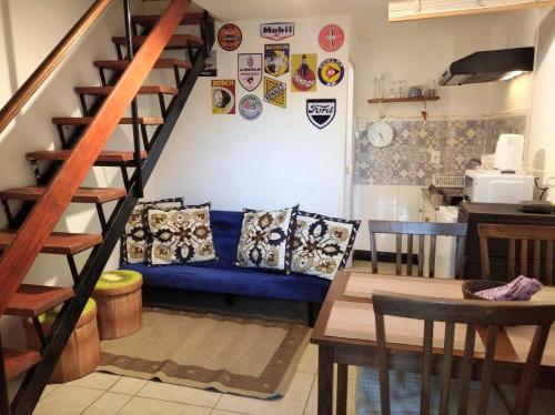Habitación con sofá azul y almohadas en una escalera. en Stilo Duplex En Punta Carretas, en Montevideo