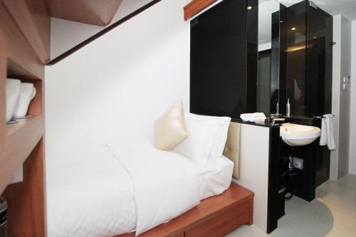 a bathroom with a white bed and a sink at Arton Boutique Hotel in Singapore