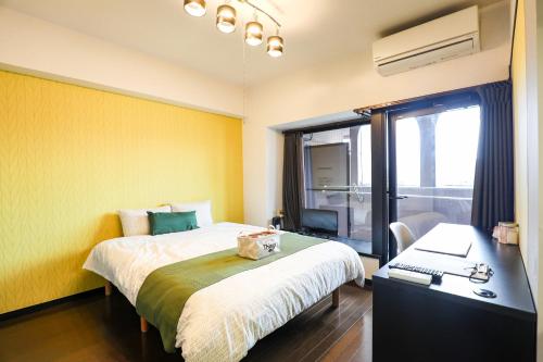a bedroom with a bed and a desk with a laptop at SUMIYOSHI APARTMENT Hotel 住吉アパートメントホテル in Fukuoka