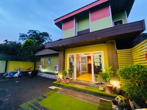 a colorful house with a lawn in front of it at Pakor Boutique Resort in Phangnga