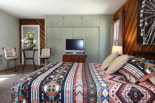 a bedroom with a bed and a flat screen tv at Kern Riverview Inn in Kernville