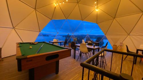 阿基塔尼亚Glamping Domos del Lago的客房设有台球桌和一些桌椅。