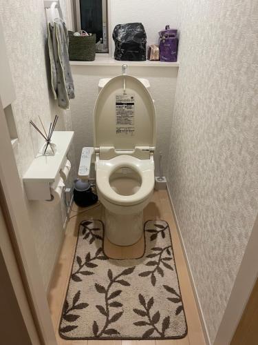 a bathroom with a toilet with a rug on the floor at Bessalov Home 2nd room friendly house in Tokyo