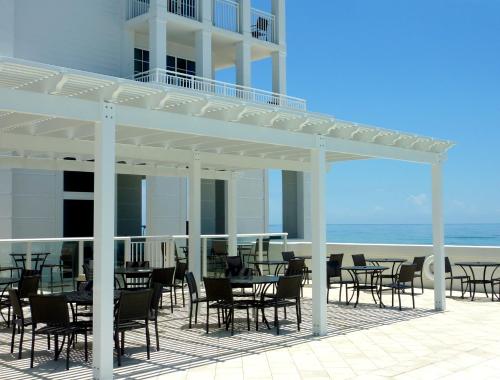 a patio with tables and chairs on the beach at The Pensacola Beach Resort in Pensacola Beach