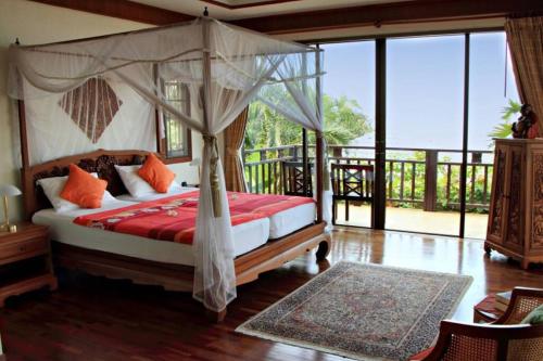 a bedroom with a canopy bed and a balcony at 4 Bedroom 300 degrees Sea View Villa SDV139A-By Samui Dream Villas in Koh Samui 