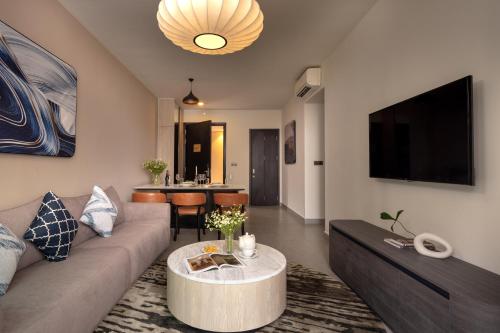 a living room with a couch and a table at Somerset Feliz Ho Chi Minh City in Ho Chi Minh City