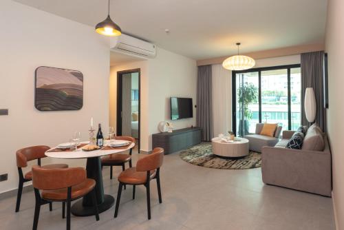 a living room with a table and chairs and a couch at Somerset Feliz Ho Chi Minh City in Ho Chi Minh City