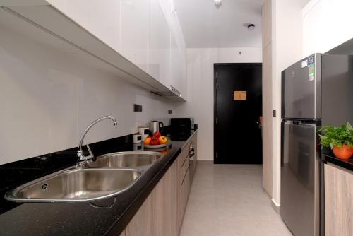 a kitchen with a sink and a refrigerator at Somerset Feliz Ho Chi Minh City in Ho Chi Minh City