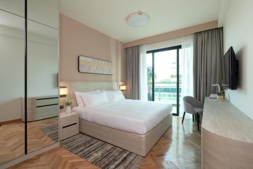 a hotel room with a bed and a sliding glass door at Somerset Feliz Ho Chi Minh City in Ho Chi Minh City