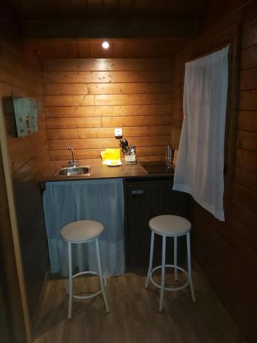 a kitchen with two stools and a sink in a cabin at Los Duendes in El Puerto de Santa María