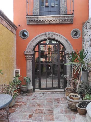 an entrance to a building with an arch and plants at Nunõ in San Miguel de Allende