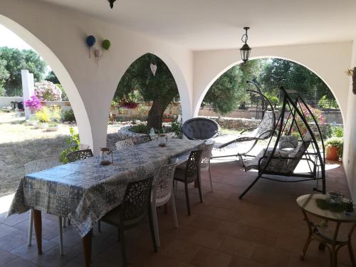 una sala da pranzo con un lungo tavolo e sedie di Trullo Alessandro e Villa Raffaela a San Vito dei Normanni