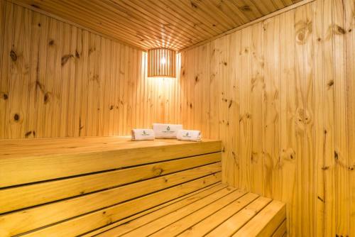 a sauna with wooden walls and a wooden floor at Urban Green Hotel & Suites in San José