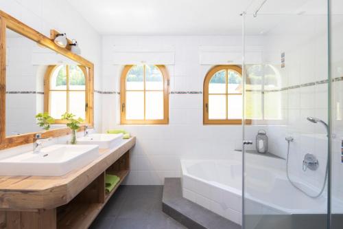 a white bathroom with two sinks and a shower at Oberhaslachhof in Reith im Alpbachtal