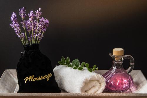 a table with a bottle of vinegar and a vase with flowers at Urban Green Hotel & Suites in San José