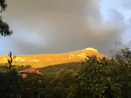 a mountain in the distance with a house and trees at Hospedagem Sabor Da Trilha in Vale do Capao
