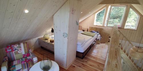 a bedroom with a bed in the middle of a attic at Zielony domek nad Marychą w Budwieć in Stanowisko
