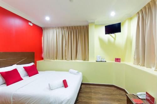 1 dormitorio con 1 cama con paredes rojas y amarillas en Hotel Sunjoy9 Bandar Sunway, en Petaling Jaya