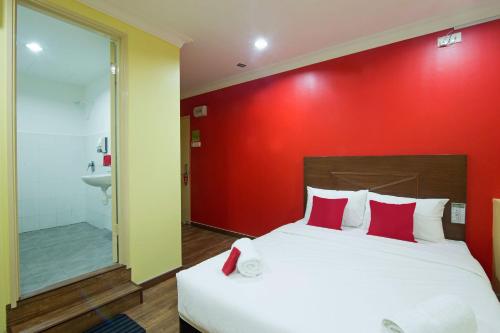 a bedroom with a large bed with a red wall at Hotel Sunjoy9 Bandar Sunway in Petaling Jaya