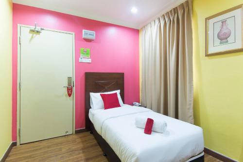 a bedroom with two beds and a pink wall at Hotel Sunjoy9 Bandar Sunway in Petaling Jaya