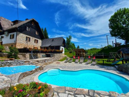 een zwembad in een tuin naast een huis bij Plitvice Ethno House in Jezerce
