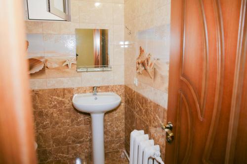 a bathroom with a sink and a mirror and a door at Этаж под ключ в гостевом доме in Anapa