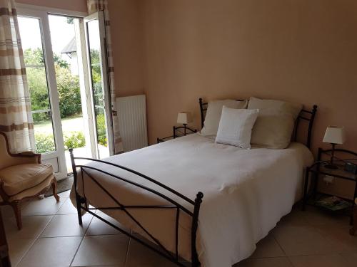 a bedroom with a large bed with white sheets and pillows at La Montignonne in Montigny-sur-Loing