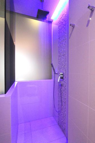 a bathroom with a shower with purple lighting at Arton Boutique Hotel in Singapore