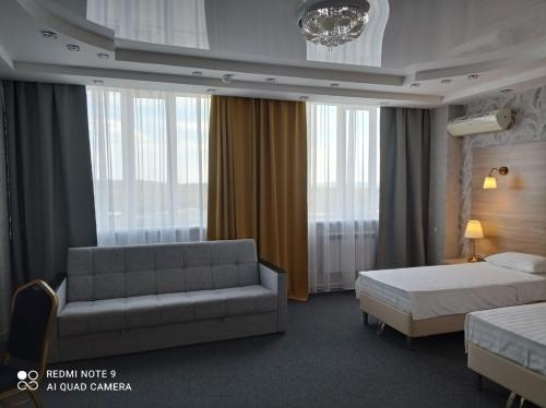 KachkanarにあるHotel Pyaterochka Luxのベッドとソファ付きのホテルルーム