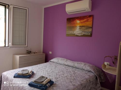 ein Schlafzimmer mit einem Bett mit einer lila Wand in der Unterkunft Verde Mare in Alassio