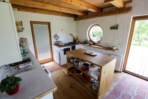 uma cozinha com uma mesa de madeira num quarto em Unique Cottage House With Panoramic View On Ravnik em Hotedršica