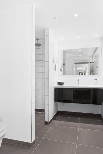 a bathroom with a sink and a large mirror at Best Western Plus Hotel Fredericia in Fredericia
