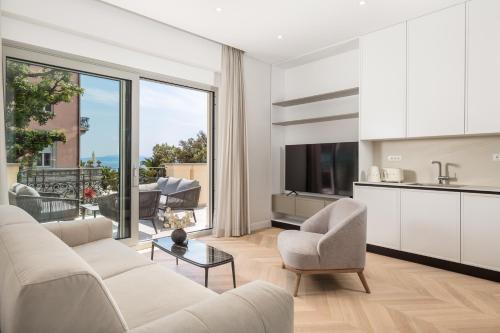 a living room with white furniture and a large window at Plaza Apartments in Opatija